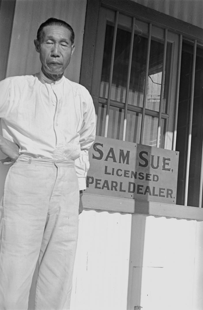 A man standing outside his store.